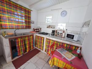 una pequeña cocina con fregadero y microondas en O 4 épices gites, en Capesterre-Belle-Eau