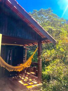 a hammock hanging from a porch of a house at Pousada Bella Ana in Visconde De Maua
