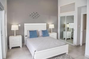 a bedroom with a bed with blue pillows and a mirror at 246D South Finger in Jolly Harbour +15 photos
