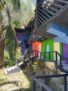 een kleurrijk gebouw met een trap en een trapleuning bij Airport Inn Roatan in Coxen Hole
