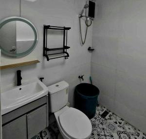 a bathroom with a sink and a toilet and a mirror at 2 Bedroom, 1 Bathroom Home with street parking in Sibulan