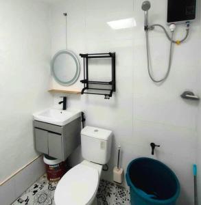 a bathroom with a toilet and a sink and a mirror at 2 Bedroom, 1 Bathroom Home with street parking in Sibulan