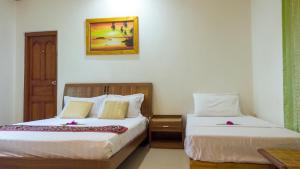 1 dormitorio con 2 camas y una foto en la pared en Malas Island View, en Fulidhoo