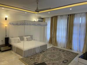 1 dormitorio con cama, cortinas y alfombra en West Coast Villa en Limbe