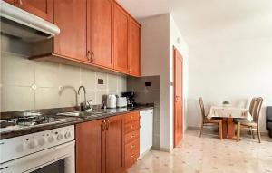 a kitchen with wooden cabinets and a white stove top oven at 1 Bedroom Cozy Apartment In Kukci in Kukci
