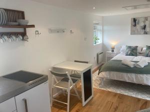 a bedroom with a bed and a table and a desk at The Garden Studio in Broadstairs
