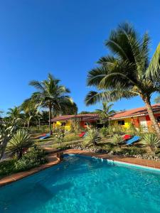 a swimming pool in front of a house with palm trees at Residence Las Lajas in Las Lajas