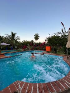 eine Person, die in einem Pool schwimmt in der Unterkunft Residence Las Lajas in Las Lajas