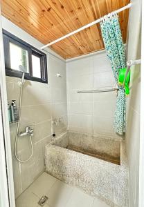 uma casa de banho com um chuveiro e uma banheira em Mei Nong Villa em Meinong