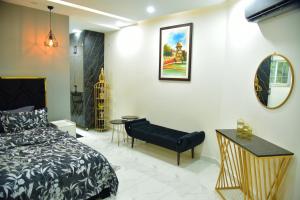 a bedroom with a bed and a table and a mirror at Chic Noir 1 Bedroom Apartment Gulberg in Lahore