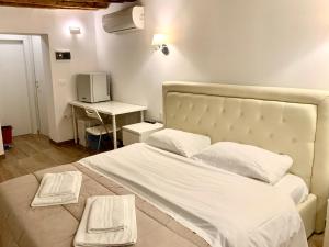 1 cama blanca grande con 2 toallas blancas. en Casa Giardini, en Venecia