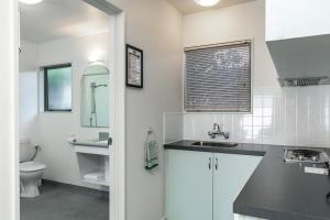 a white bathroom with a sink and a toilet at Jasmine Court Motel in Picton