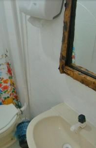 a small bathroom with a toilet and a window at Pousada do beco in Caravelas