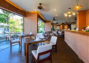 een restaurant met tafels en stoelen en een bar bij Hoi An Ocean Front Hotel in Hội An
