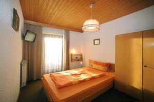 ein Schlafzimmer mit einem Bett und einem großen Fenster in der Unterkunft Pension Waldeck in Langdorf