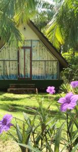 a house with some purple flowers in front of it at Phu Nam House - Resort in Phú Quốc