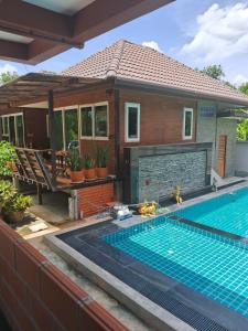 a house with a swimming pool in front of a house at Rabbit House แรบบิท เฮ้าส์ in Ban Han Tra Fang Nua