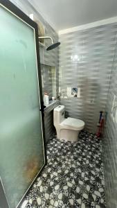 a bathroom with a toilet and a tiled floor at Phu Nam House - Resort in Phú Quốc