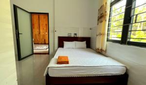 a bedroom with a bed with an orange towel on it at Phu Nam House - Resort in Phú Quốc