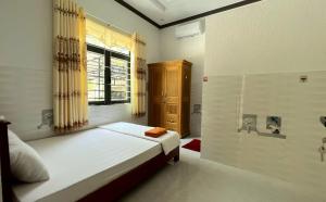 a small bedroom with a bed and a window at Phu Nam House - Resort in Phú Quốc