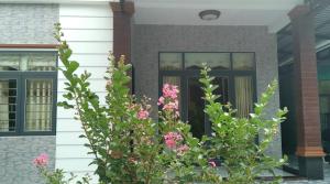 a front door of a house with pink flowers at Phu Nam House - Resort in Phú Quốc