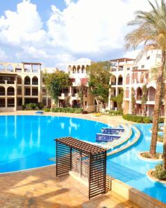 una piscina en un complejo con palmeras y edificios en Flat Luxury 2 bed rooms apartment talabay aqaba, en Áqaba