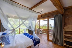a bedroom with a canopy bed and a balcony at Morin Resort in Nusa Lembongan