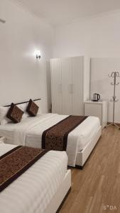 ein Hotelzimmer mit 2 Betten und einem Kreuz an der Wand in der Unterkunft K-BOSS Hotel in Bắc Ninh