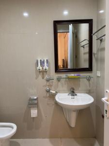 ein Badezimmer mit einem Waschbecken, einem Spiegel und einem WC in der Unterkunft K-BOSS Hotel in Bắc Ninh