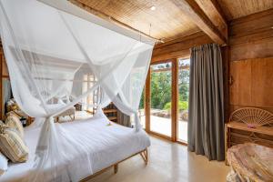 a bedroom with a bed with a mosquito net at Morin Resort in Nusa Lembongan