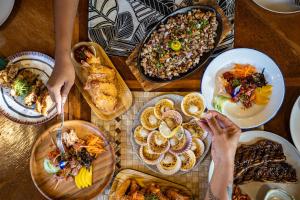 a wooden table with plates of food on it at Haole Surf Hostel in General Luna