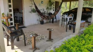 eine Terrasse mit einer Hängematte sowie einem Tisch und Stühlen in der Unterkunft Casa Viçosa 5km centro in Viçosa do Ceará