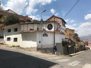 een wit gebouw aan de straatkant bij Saqray Hostel in Cuzco