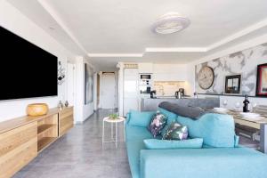 ein Wohnzimmer mit einer blauen Couch und einer Küche in der Unterkunft Apartment in Palm Mar - Insel Teneriffa 44996 in Palm-mar