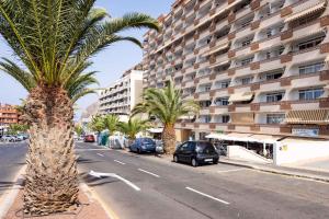 eine Straße mit Palmen und einem großen Gebäude in der Unterkunft Apartment in Palm Mar - Insel Teneriffa 44996 in Palm-mar