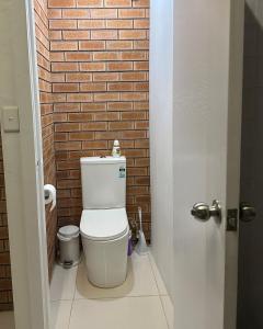 een badkamer met een toilet en een bakstenen muur bij Culture Paradise 3BR 2 story Townhouse Cabramatta in Cabramatta