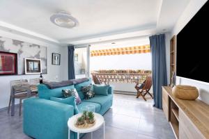 ein Wohnzimmer mit einer blauen Couch und einem Fernseher in der Unterkunft Apartment in Palm Mar - Insel Teneriffa 44996 in Palm-mar
