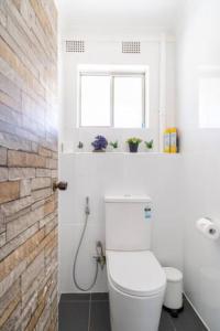 een witte badkamer met een toilet en een raam bij Culture Paradise 3BR 2 story Townhouse Cabramatta in Cabramatta
