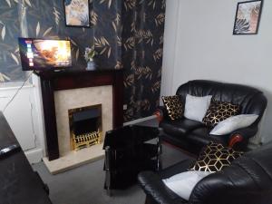 a living room with a couch and a fireplace at Comfortable 4-Bed House in Hucknall Nottingham in Nottingham +15 photos
