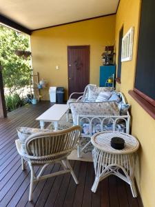a porch with chairs and a table and a couch at Pomona Noosa Hinterland Homestay in Pomona