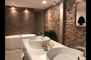ein Badezimmer mit einem weißen Waschbecken und einer Badewanne in der Unterkunft Loft Condesa in Mexiko-Stadt