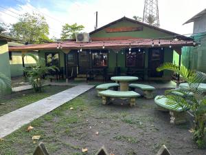 a building with a table and benches in front of it at Caribbean View in Tortuguero