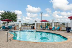a small swimming pool with chairs and umbrellas at Best Western PLUS Victoria Inn & Suites in Victoria
