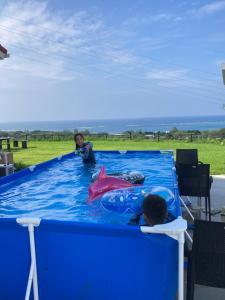 a child playing with a shark in a pool at ZARATAN exclusive stay for one group only in Motobu