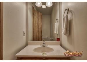 a bathroom with a sink and a large mirror at Honeymoon Cabin with Great Mountain View and Hot Tub in Gatlinburg +26 photos