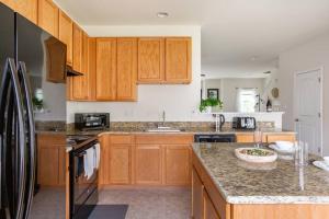 a kitchen with wooden cabinets and a granite counter top at Spacious and Modern Townhome minutes from UDel in Newark