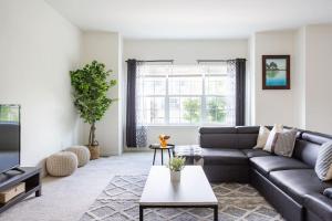 a living room with a couch and a table at Spacious and Modern Townhome minutes from UDel in Newark