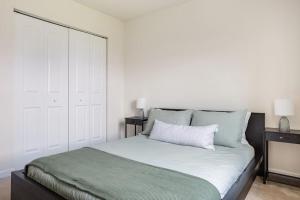 a bedroom with a white bed with a green blanket at Spacious and Modern Townhome minutes from UDel in Newark