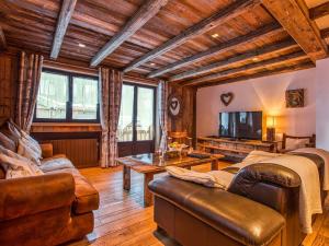 ein Wohnzimmer mit Sofa und Fernseher in der Unterkunft Appartement 112m² Courchevel 1850, centre, proche pistes, 3 chambres, balnéo, hammam, WIFI - FR-1-631-165 in Courchevel