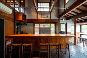 a kitchen with a bar with stools in it at Enokiya Ryokan in Yufu
